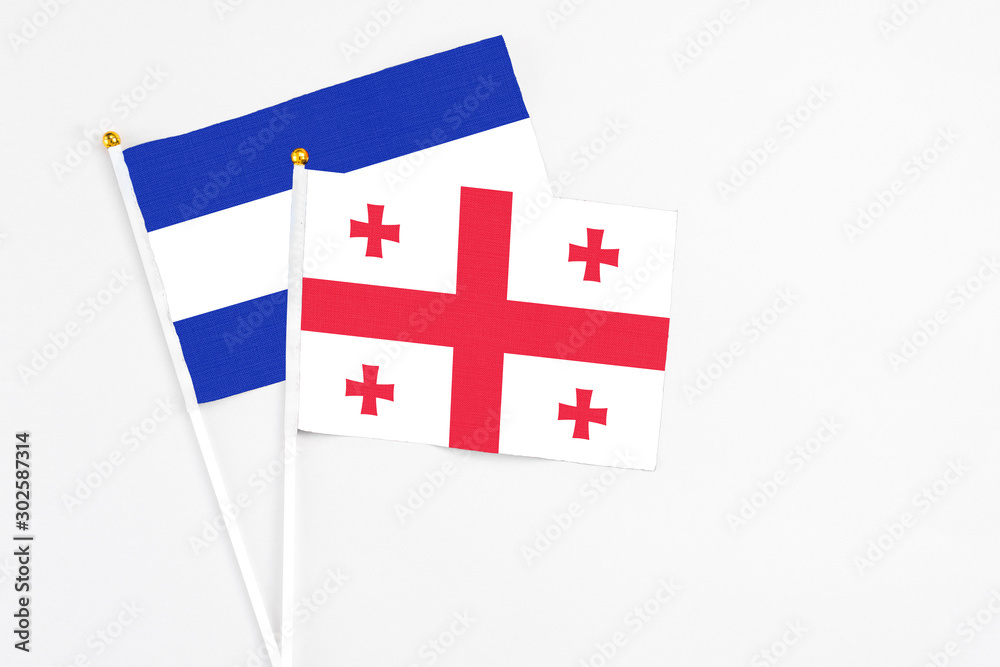 Georgia and El Salvador stick flags on white background. High quality fabric, miniature national flag. Peaceful global concept.White floor for copy space.