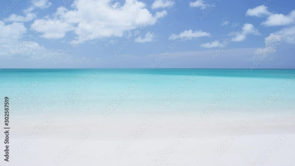 SEAMLESS LOOP VIDEO: Beach background - Caribbean beach with turquoise water and white sand beach and blue sky. SEAMLESS LOOP VIDEO: Beach background - Caribbean beach with turquoise water and white sand beach and blue sky.