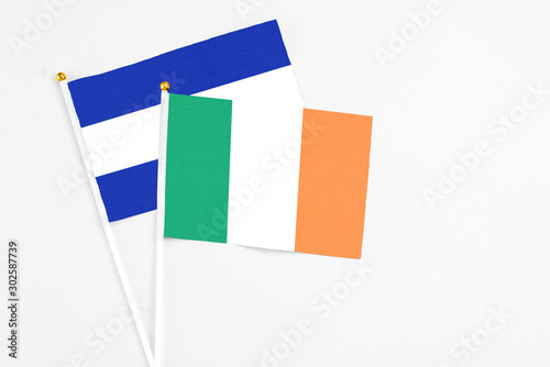 Ireland and El Salvador stick flags on white background. High quality fabric, miniature national flag. Peaceful global concept.White floor for copy space. photo