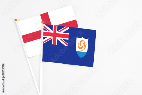 Anguilla and England stick flags on white background. High quality fabric, miniature national flag. Peaceful global concept.White floor for copy space.