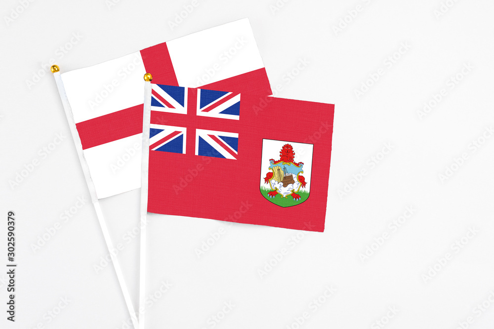 Bermuda and England stick flags on white background. High quality fabric, miniature national flag. Peaceful global concept.White floor for copy space.