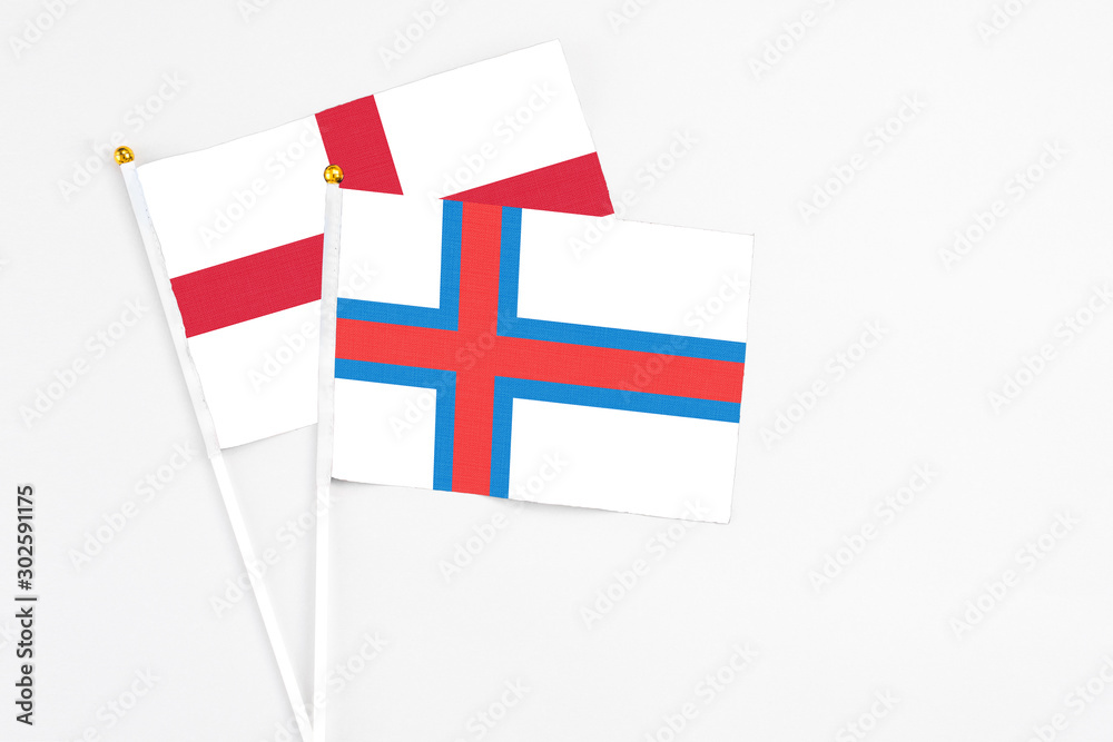 Faroe Islands and England stick flags on white background. High quality fabric, miniature national flag. Peaceful global concept.White floor for copy space.