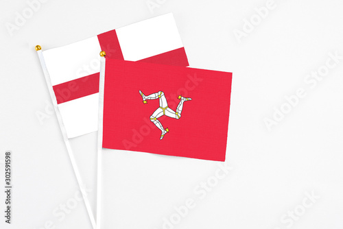 Isle Of Man and England stick flags on white background. High quality fabric, miniature national flag. Peaceful global concept.White floor for copy space.
