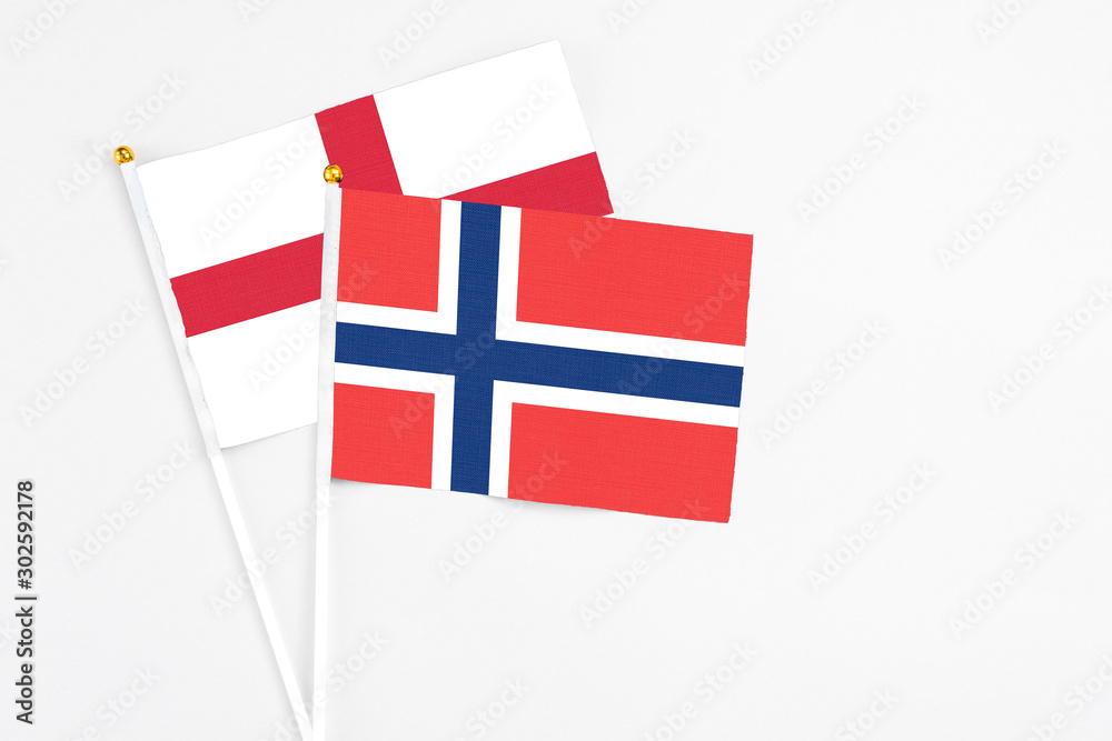 Norway and England stick flags on white background. High quality fabric, miniature national flag. Peaceful global concept.White floor for copy space.