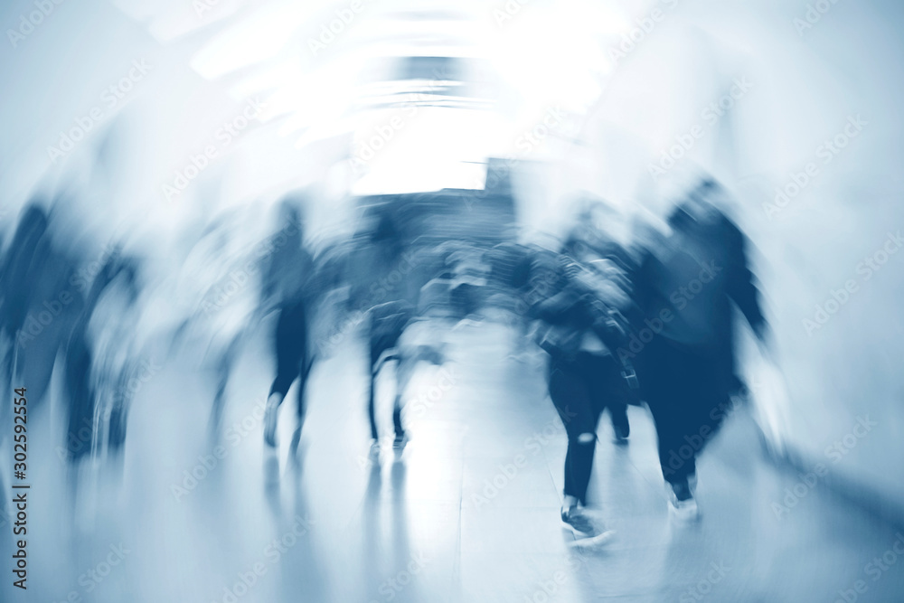 People walking in an underground passage. Silhouettes of passengers in blur. Blurred image of moving people.