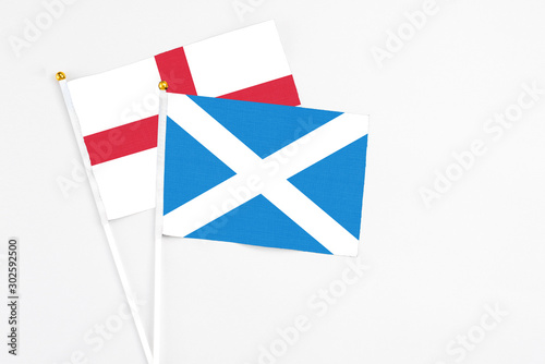 Scotland and England stick flags on white background. High quality fabric, miniature national flag. Peaceful global concept.White floor for copy space.