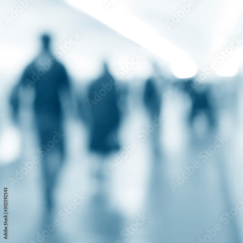 People walking in an underground passage. Silhouettes of passengers in blur. Blurred image of moving people.