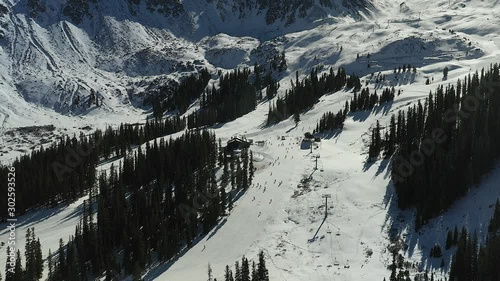 Skiers coming down Arapahoe Basin at the top of Black Mountain express at Black mountain Lodge in Summit county Colorado photo