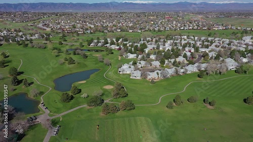 Panning Aerial drone footage of the Links Golf Course, the Rocky Mountains, and surrounding neighborhoods in Lakewood Ranch, Colorado photo