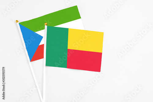 Benin and Equatorial Guinea stick flags on white background. High quality fabric  miniature national flag. Peaceful global concept.White floor for copy space.