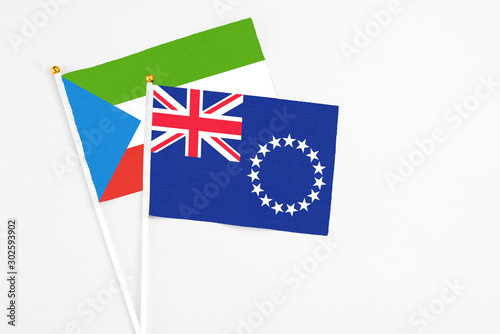 Cook Islands and Equatorial Guinea stick flags on white background. High quality fabric, miniature national flag. Peaceful global concept.White floor for copy space.