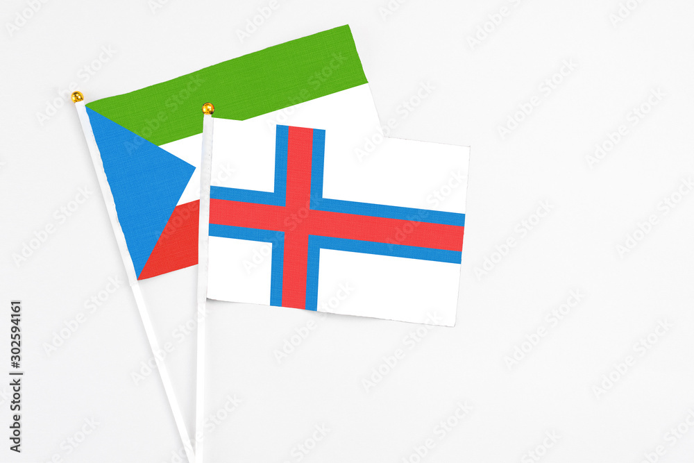 Faroe Islands and Equatorial Guinea stick flags on white background. High quality fabric, miniature national flag. Peaceful global concept.White floor for copy space.