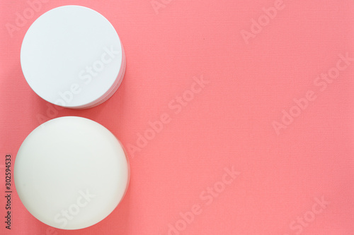 Top view with a cosmetic jars on a pink background. Health and beauty. Mockup with copyspace