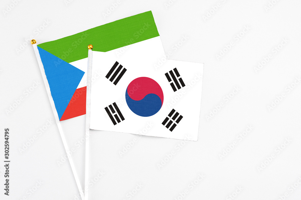 South Korea and Equatorial Guinea stick flags on white background. High quality fabric, miniature national flag. Peaceful global concept.White floor for copy space.