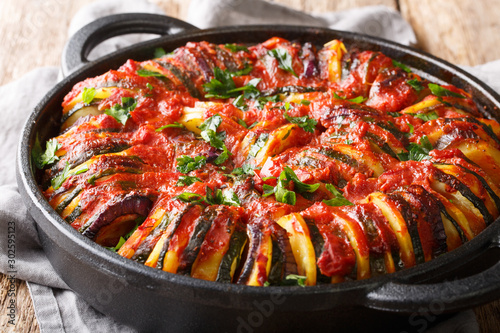 Mediterranean baked various vegetables in tomato sauce close-up in a pan. horizontal