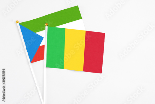 Mali and Equatorial Guinea stick flags on white background. High quality fabric, miniature national flag. Peaceful global concept.White floor for copy space.