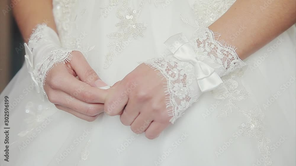 female hands in white gloves close-up. Embroidery, bow, texture. Wedding fashion and accessories concept female hands in white gloves close-up. Embroidery, bow, texture. Wedding fashion and accessories concept