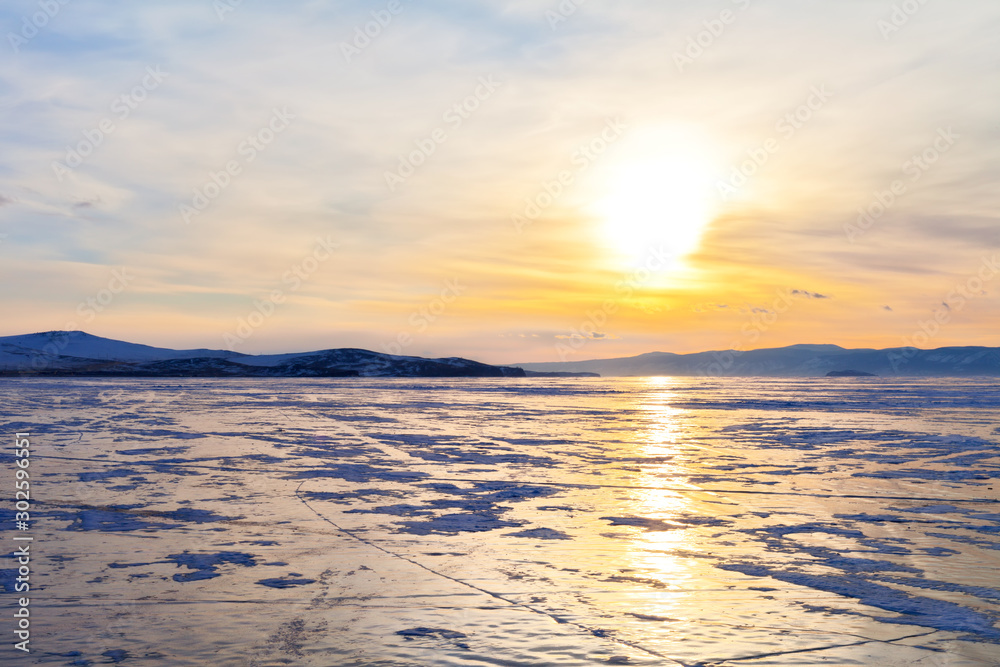 Winter Baikal Lake. Beautiful sunset over the Small Sea Strait at March evening. Ice travel. Natural background