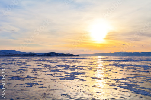 Winter Baikal Lake. Beautiful sunset over the Small Sea Strait at March evening. Ice travel. Natural background