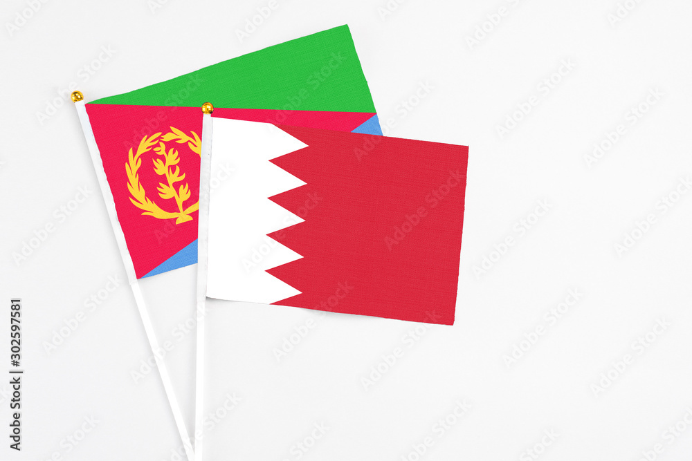 Obraz premium Bahrain and Eritrea stick flags on white background. High quality fabric, miniature national flag. Peaceful global concept.White floor for copy space.