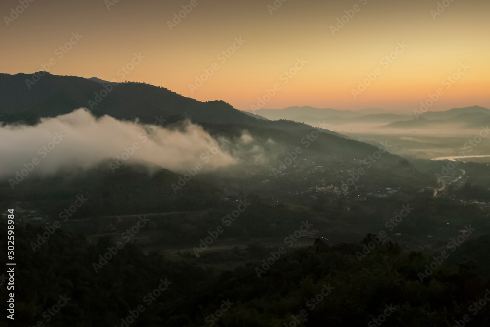Mountain view panorama morning of soft mist moving around top hill with sea of fog and yellow sun light in the sky background, sunrise at Wat Tha Ton, Tha Ton, Fang, Chiang Mai, Thailand.