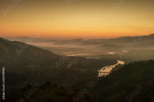 Mountain view morning above Kok river around with sea of mist, mountain and yellow light in the sky background, sunrise at Wat Tha Ton, Tha Ton, Fang, Chiang Mai, Thailand.