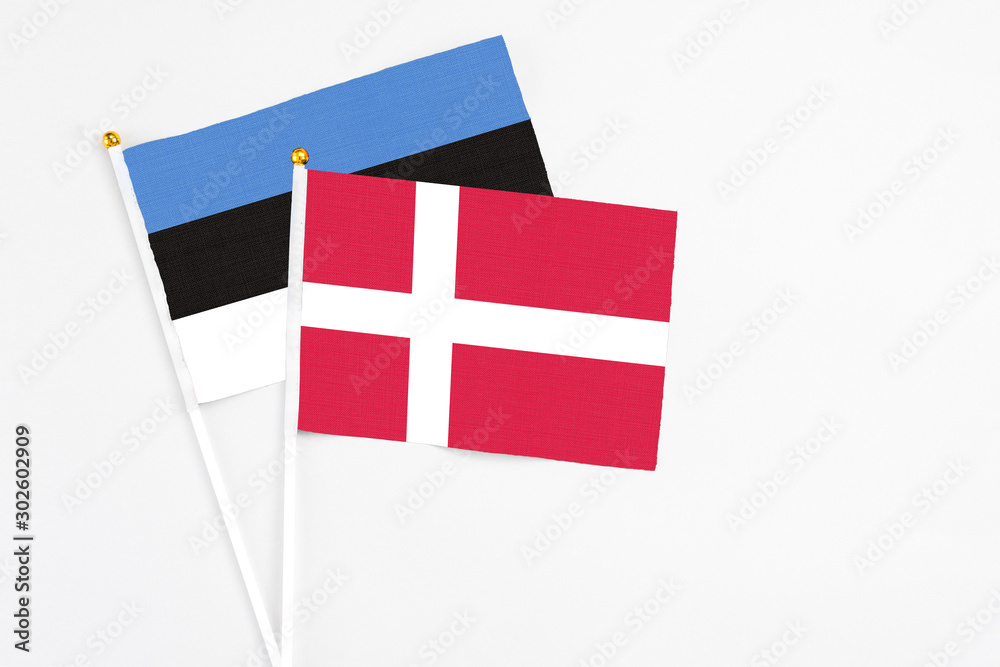 Denmark and Estonia stick flags on white background. High quality fabric, miniature national flag. Peaceful global concept.White floor for copy space.