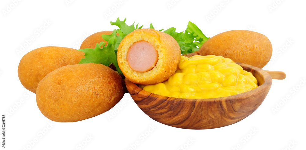 Mini party corn dogs on wooden sticks with a wooden bowl of American mustard isolated on a white background Mini party corn dogs on wooden sticks with a wooden bowl of American mustard isolated on a white background