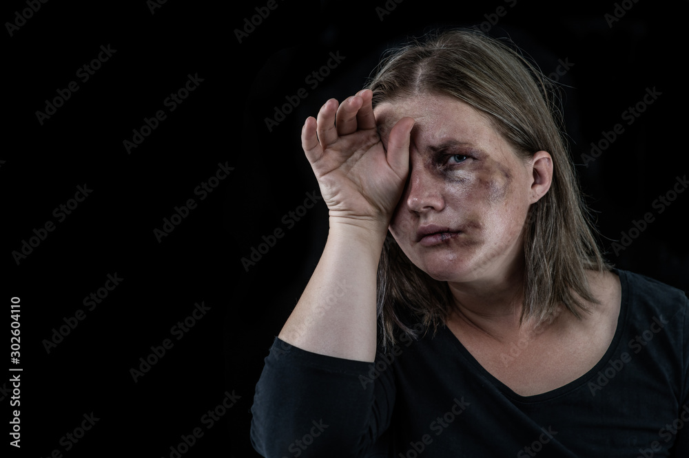 Crying woman victim of domestic violence and abuse. Isolated on dark background