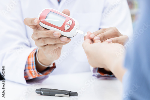 Pharmacist in pharmacy determines blood glucose level for insulin determination in patient  Sample blood analysis to determine blood group.