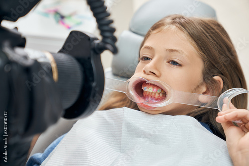 Photos Using mouth retractor and equipment in stomatology.