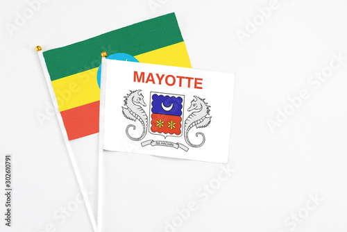 Mayotte and Ethiopia stick flags on white background. High quality fabric, miniature national flag. Peaceful global concept.White floor for copy space.