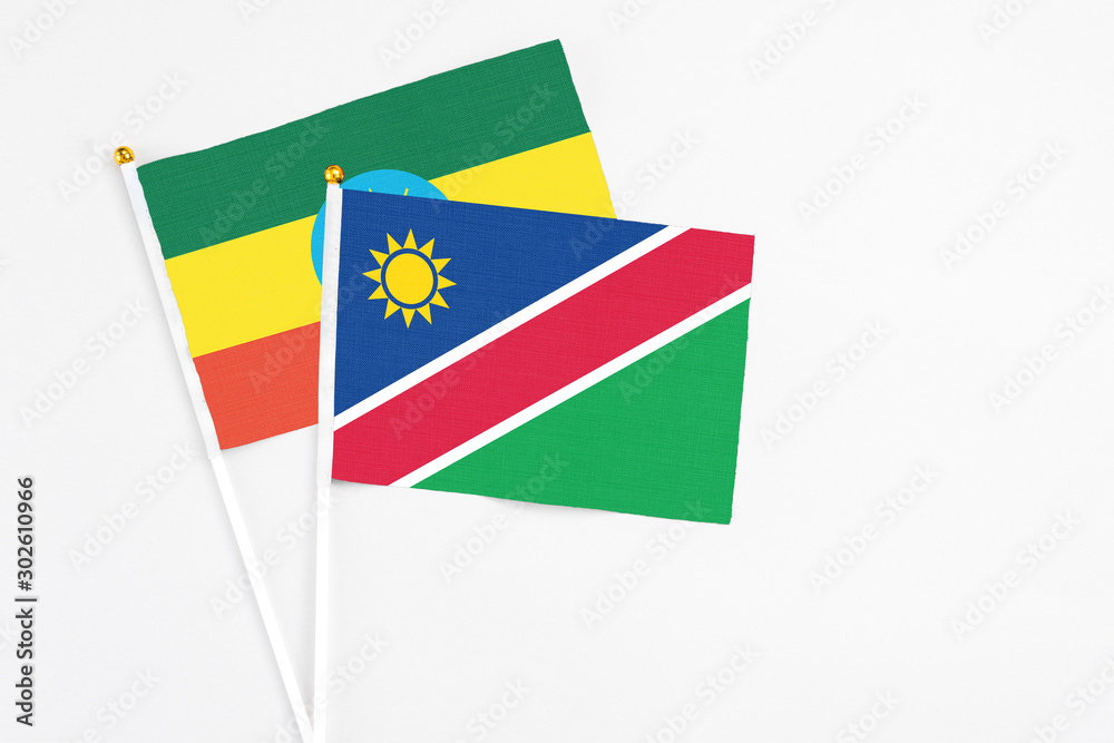 Namibia and Ethiopia stick flags on white background. High quality fabric, miniature national flag. Peaceful global concept.White floor for copy space. Namibia and Ethiopia stick flags on white background. High quality fabric, miniature national flag. Peaceful global concept.White floor for copy space.
