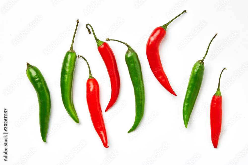Red and green chili pepper on a white background. Red and green chili pepper of different shapes isolated on white background