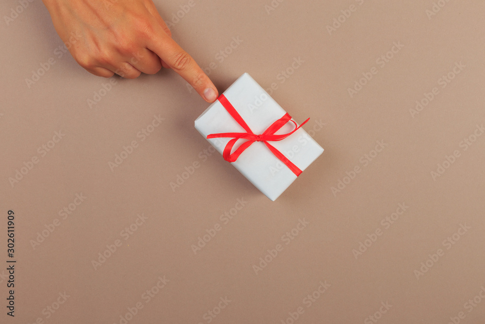 Obraz premium gift in female hands on a colored background top view. - Image
