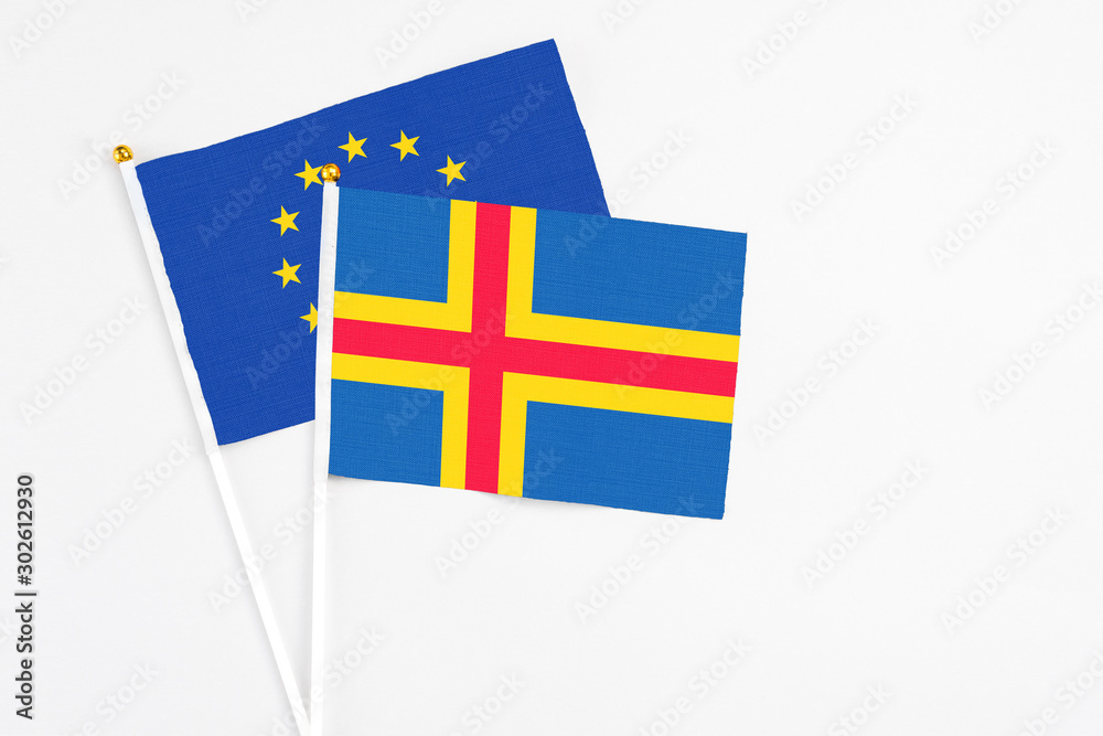 Aland Islands and European Union stick flags on white background. High quality fabric, miniature national flag. Peaceful global concept.White floor for copy space.