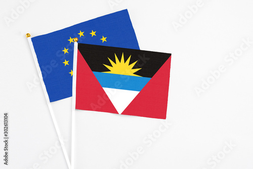 Free Download Antigua and Barbuda and European Union stick flags on white background. High quality fabric, miniature national flag. Peaceful global concept.White floor for copy space. - GFXLoad
