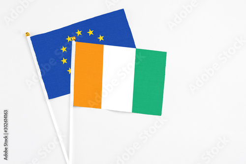 Free Download Cote D'Ivoire and European Union stick flags on white background. High quality fabric, miniature national flag. Peaceful global concept.White floor for copy space. - GFXLoad