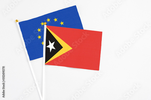 Free Download East Timor and European Union stick flags on white background. High quality fabric, miniature national flag. Peaceful global concept.White floor for copy space. - GFXLoad