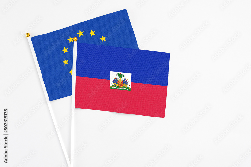 Haiti and European Union stick flags on white background. High quality fabric, miniature national flag. Peaceful global concept.White floor for copy space. Haiti and European Union stick flags on white background. High quality fabric, miniature national flag. Peaceful global concept.White floor for copy space.