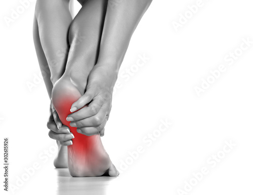 woman massaging her painful foot on white background