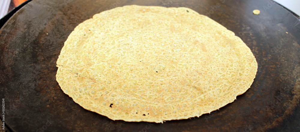 Crepe or pancake. Baking a thin pancake on a special grill. Crepe or pancake. Baking a thin pancake on a special grill.