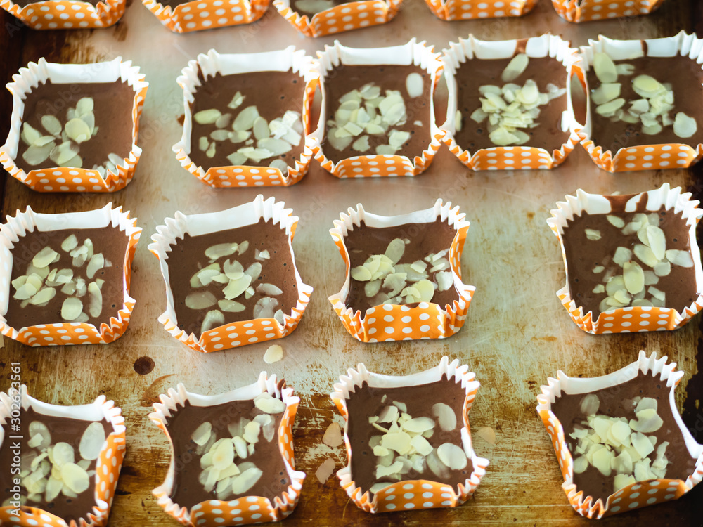 Motion blur spreading almonds sliced on homemade chocolate cupcakes on table. Motion blur spreading almonds sliced on homemade chocolate cupcakes on table.