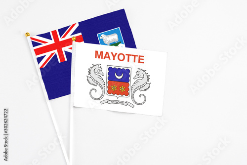 Mayotte and Falkland Islands stick flags on white background. High quality fabric, miniature national flag. Peaceful global concept.White floor for copy space.