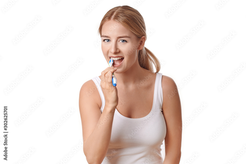 Attractive woman practicing dental hygiene brushing her teeth with a toothbrush and toothpaste to prevent tooth decay or caries , isolated on white Attractive woman practicing dental hygiene brushing her teeth with a toothbrush and toothpaste to prevent tooth decay or caries , isolated on white