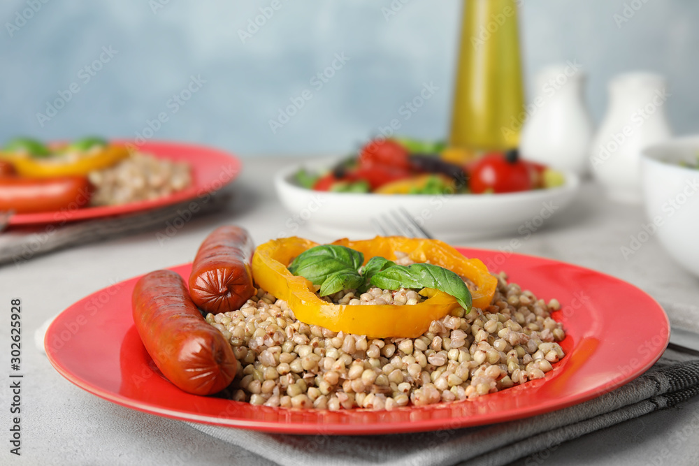 Tasty buckwheat porridge with sausages on light table. Space for text Tasty buckwheat porridge with sausages on light table. Space for text