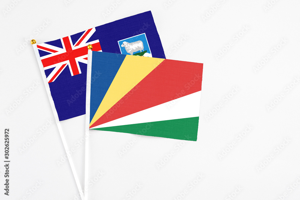 Seychelles and Falkland Islands stick flags on white background. High quality fabric, miniature national flag. Peaceful global concept.White floor for copy space. Seychelles and Falkland Islands stick flags on white background. High quality fabric, miniature national flag. Peaceful global concept.White floor for copy space.