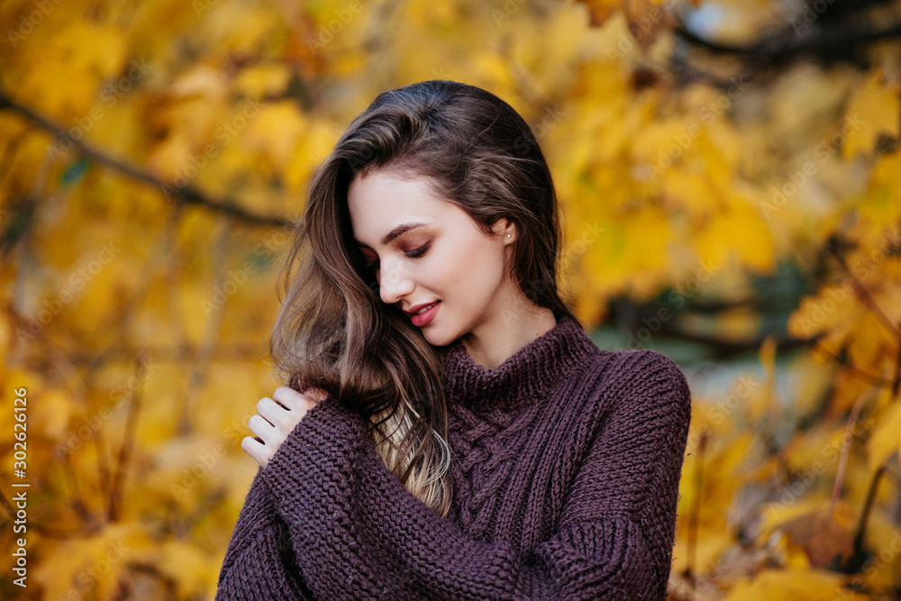 Romantic young woman in autumn park. Warm sunny weather. Fall concept Romantic young woman in autumn park. Warm sunny weather. Fall concept