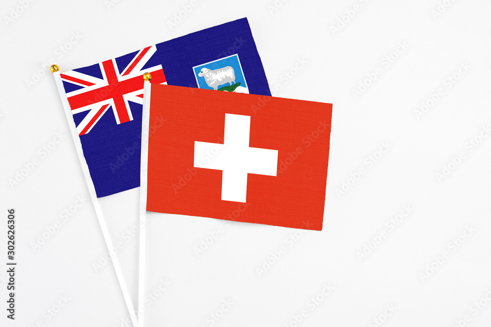 Switzerland and Falkland Islands stick flags on white background. High quality fabric, miniature national flag. Peaceful global concept.White floor for copy space.