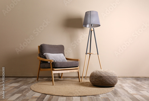Comfortable armchair with cushion in stylish room interior